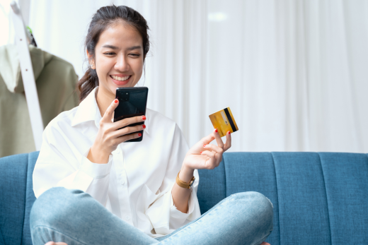 Woman holding debit card looking at phone