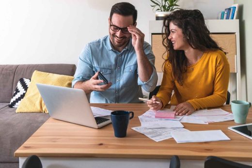 Smiling couple manage finances at home